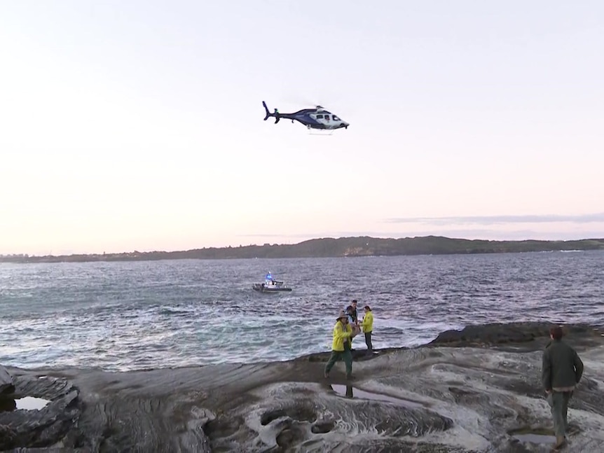A police helicopter searches the ocean.