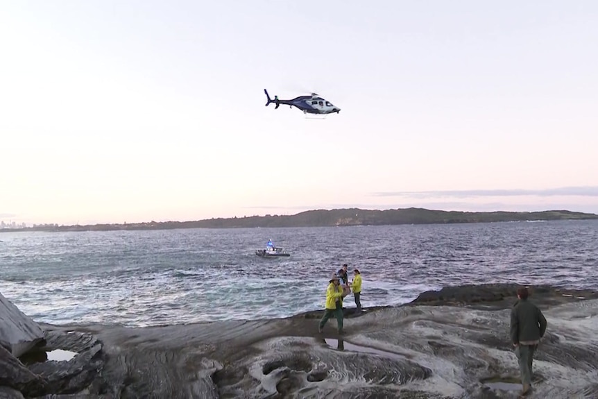A police helicopter searches the ocean.