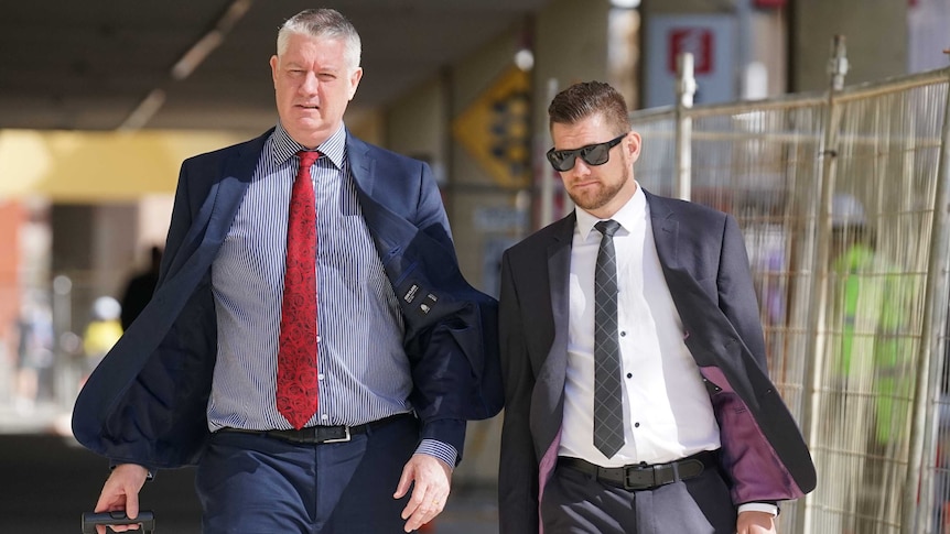 Police officer Lachlan Thomas Perhavec walks with his lawyer outside a Perth court.