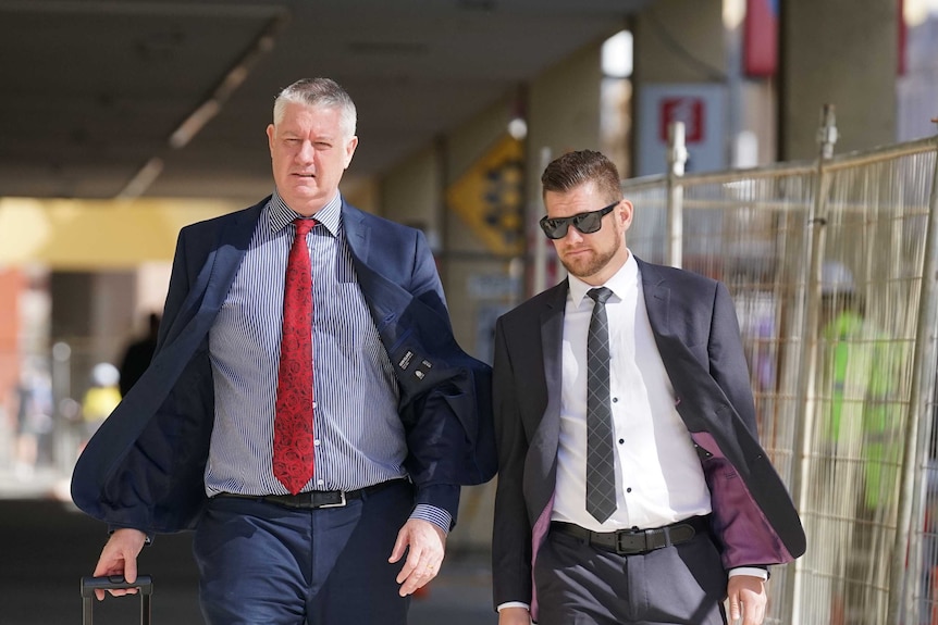 Police officer Lachlan Thomas Perhavec walks with his lawyer outside a Perth court.