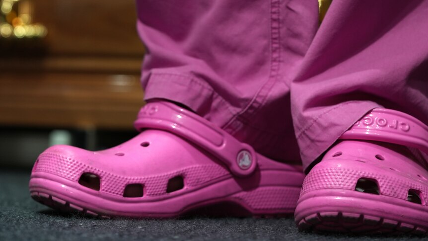 A close up of a pair of plastic pink Croc shoes