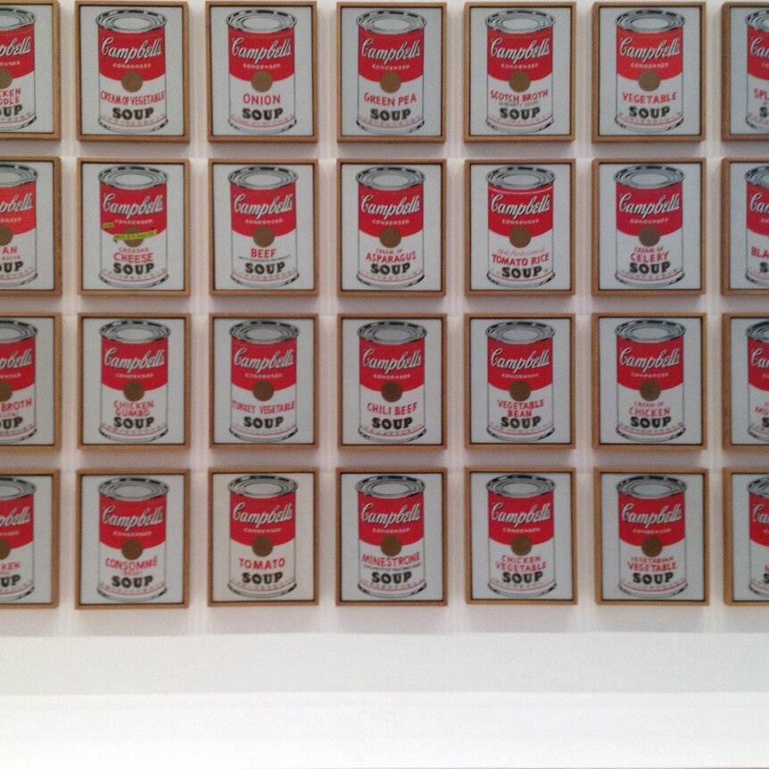 A series of Andy Warhol prints of Campbell Soup, hung on a wall