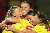 Jillaroos players hug after another try against France at the Women's Rugby League World Cup.