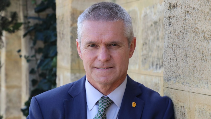 Liberal MP David Blayney leans against a wall.