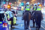 Police on horseback, foot and in vehicles on Swanston Street.