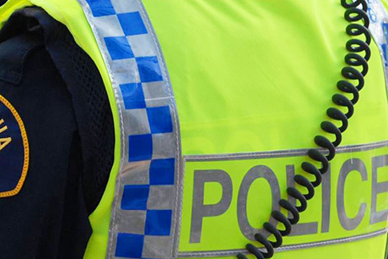 Tasmania Police officer in high-vis vest, rear view, generic image.