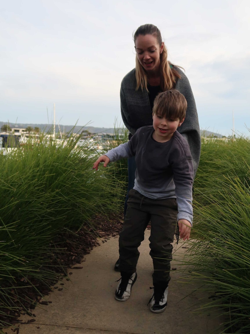 Max walks along a path in front of his mum Claire.
