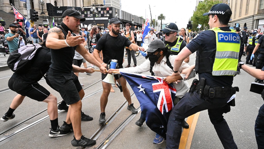 Police remove a protester during a transgender rights rally, involving opposing neo-Nazi protesters, outside Parliament House.