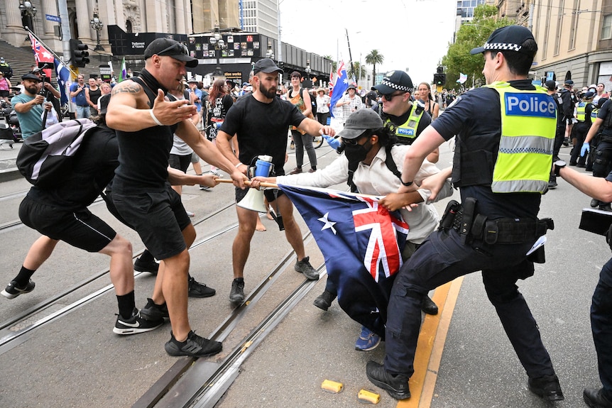 Police remove a protester during a transgender rights rally, involving opposing neo-Nazi protesters, outside Parliament House.