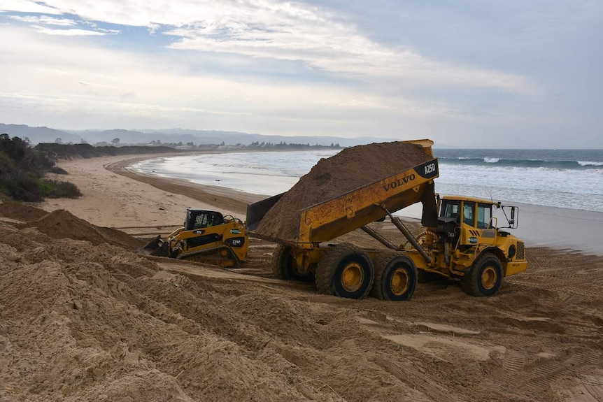 Trucks move sand at Marengo beach on the Great Ocean Road.