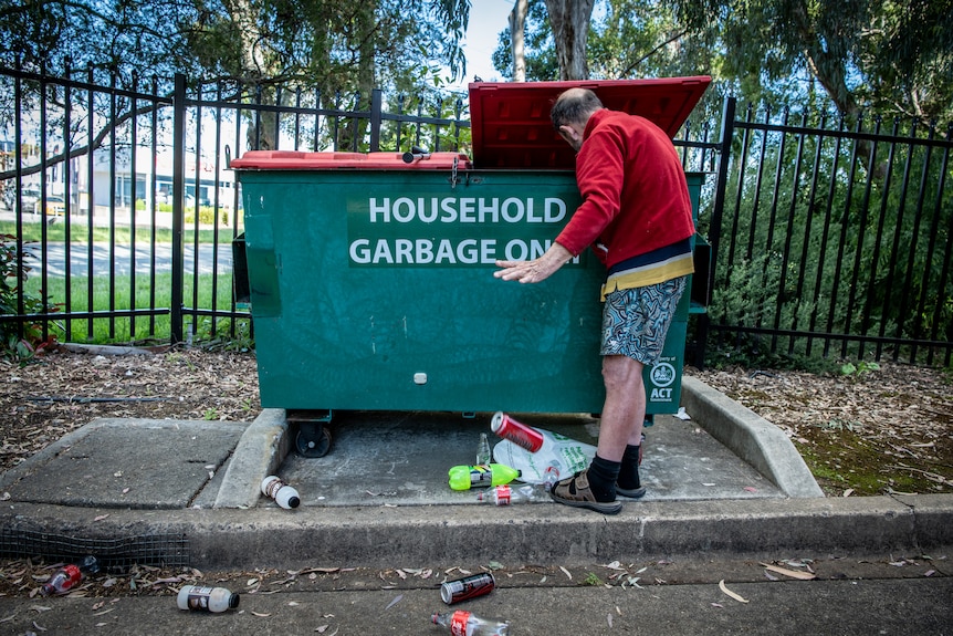 Peter Ristic looking in a bin for cans