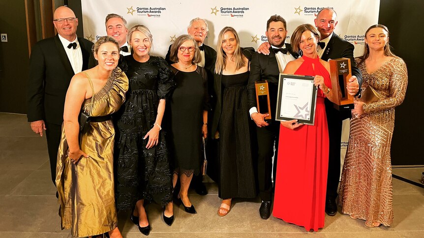 11 members of the Beef 2021 holding their 2 trophies and award at the Qantas Tourism awards evening. 