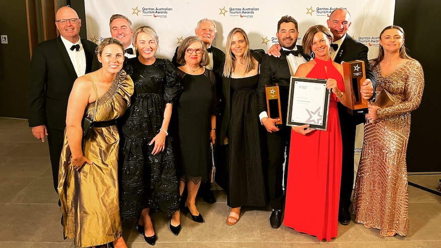 11 members of the Beef 2021 holding their 2 trophies and award at the Qantas Tourism awards evening. 