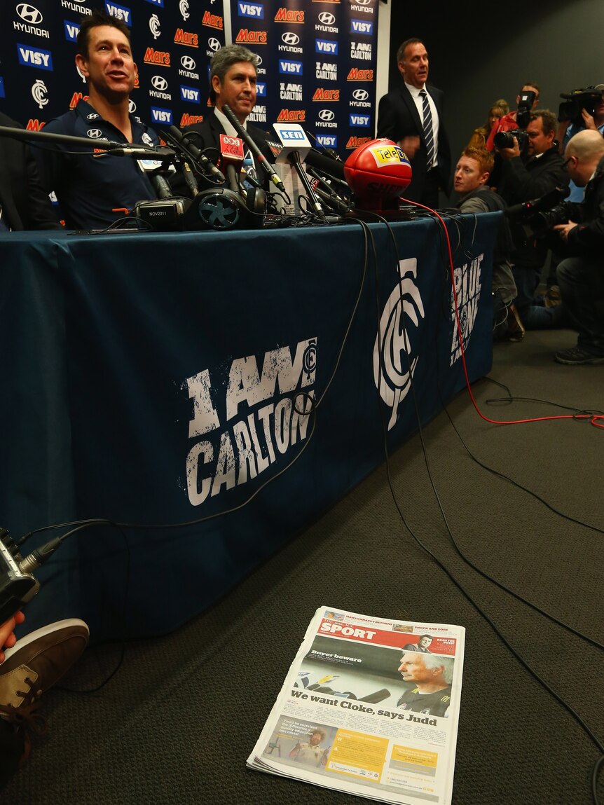 Rumour mill ...A newspaper is seen on the floor showing a picture of Mick Malthouse, as Brett Ratten speaks to the media