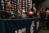 Rumour mill ...A newspaper is seen on the floor showing a picture of Mick Malthouse, as Brett Ratten speaks to the media