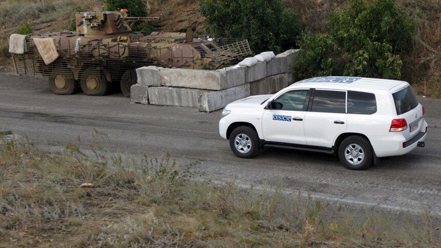 OSCE vehicle makes its way past a Ukraine military checkpoint