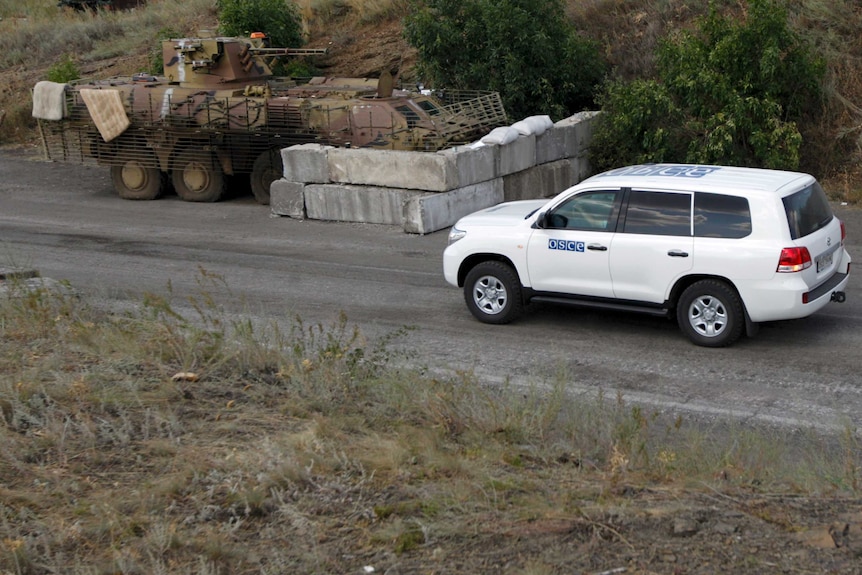 OSCE vehicle makes its way past a Ukraine military checkpoint