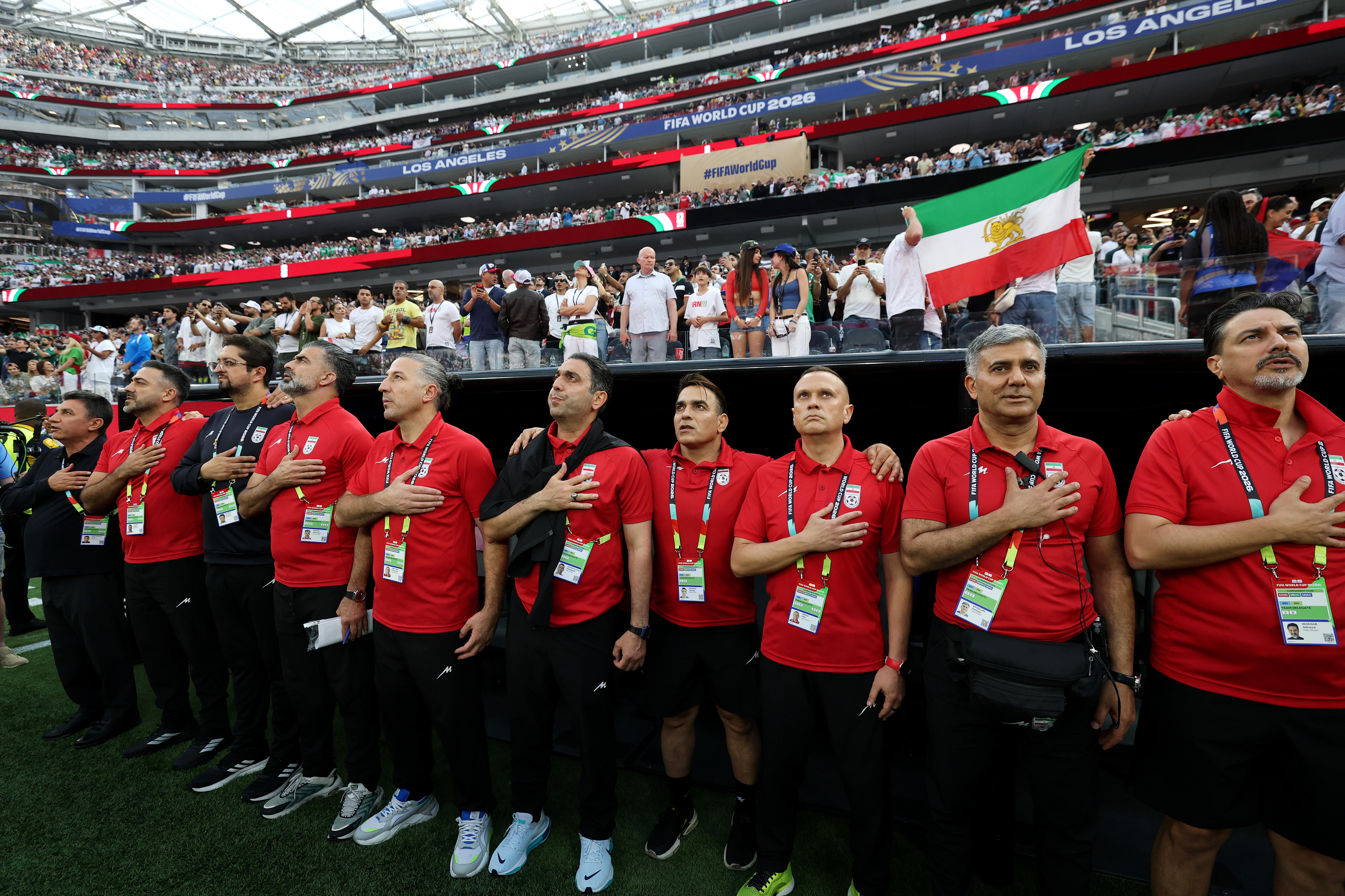 Coaching staffs of IR Iran line up for the national anthem before their world cup match.