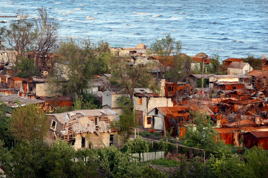 Heavily-damaged private houses are seen on the shore of the Sea of Azov in Mariupol.