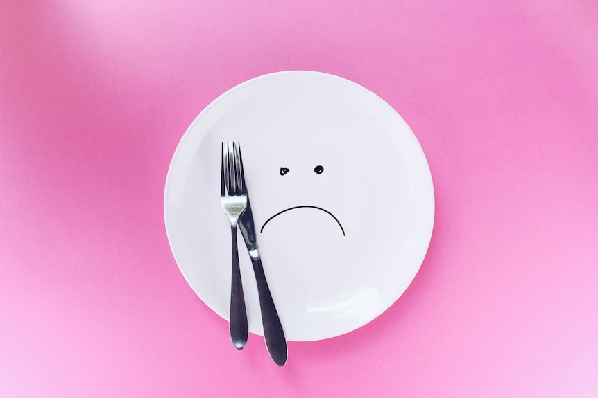 An empty plate with a sad face drawn on it