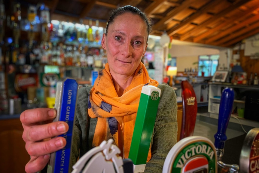 A woman pulling a beer inside a pub.