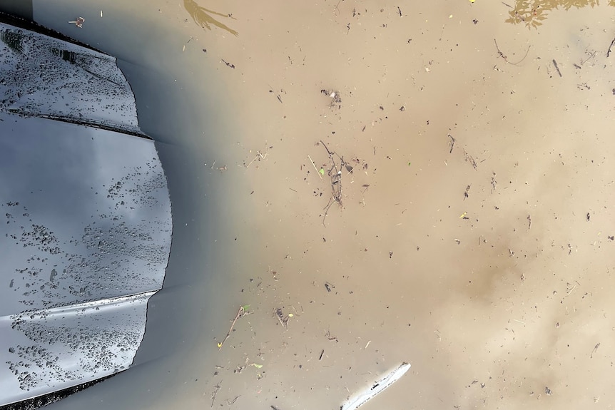 View from above of a car bonnet inundated by floodwaters