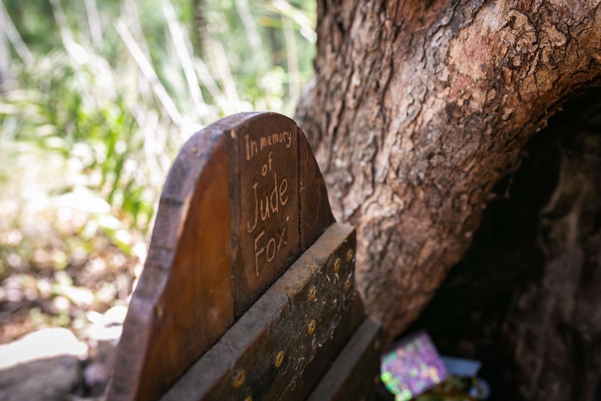 A small wood door that says 'in memory of Jude Fox'