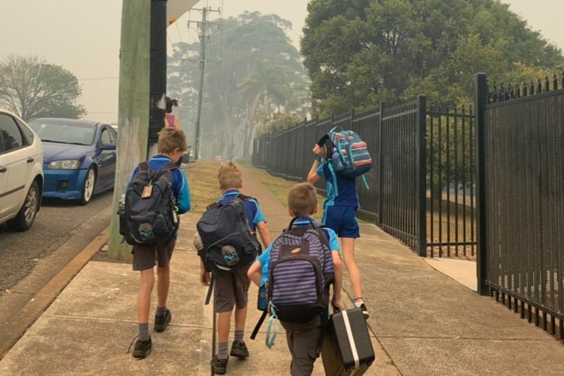 Students leaving school carrying backpacks on a smoky day