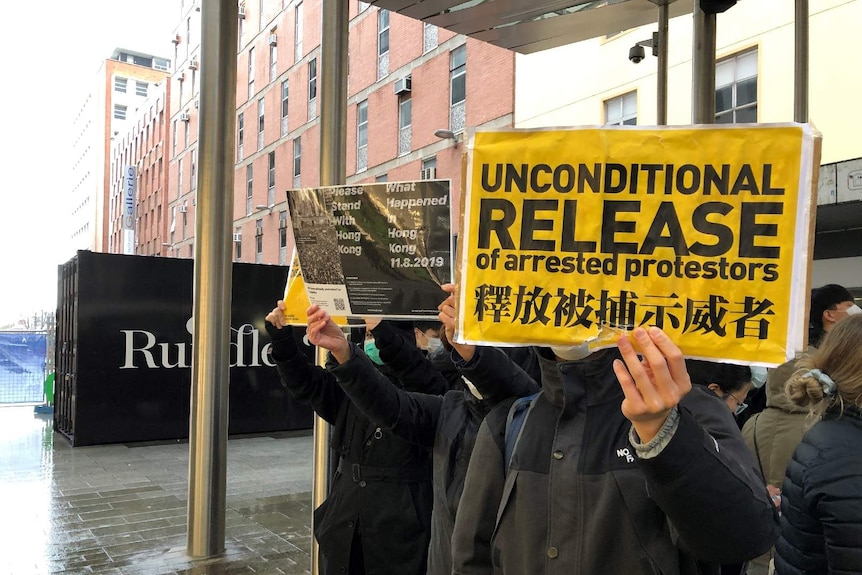 Pro-Hong Kong demonstrators hold up signs at an Adelaide rally.