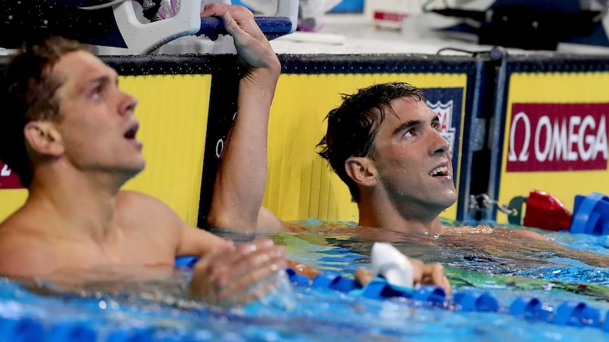 Michael Phelps (R) reacts after winning the 200m butterfly at the 2016 US Olympic swim trials.