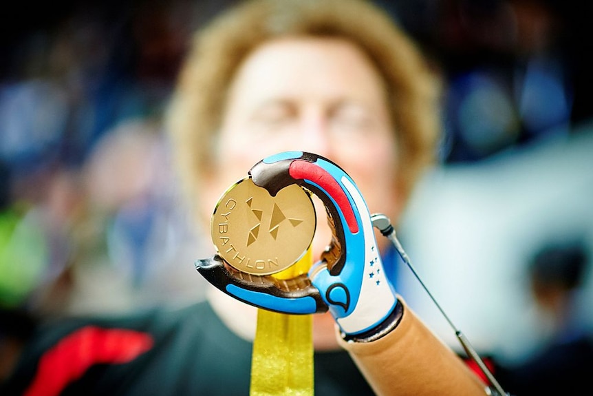 Robert Radocy of the Netherlands shows his gold medal after winning gold in the arm prosthesis race at Cybathlon