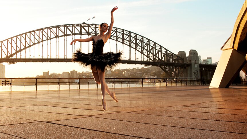 A dancer performs in front of a backdrop of the Sydney Harbour Bridge