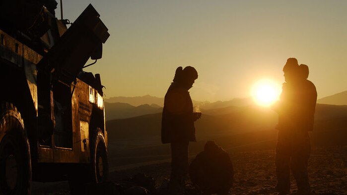 Australian soldiers stand next to their armoured tank in Afghanistan (AAP: Department of Defence)