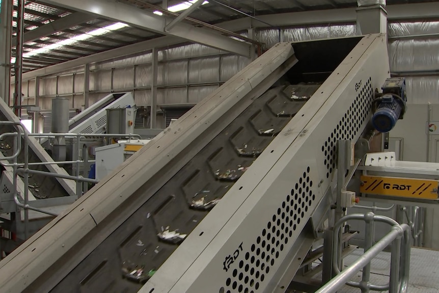 A conveyor belt with small recyclable items on it