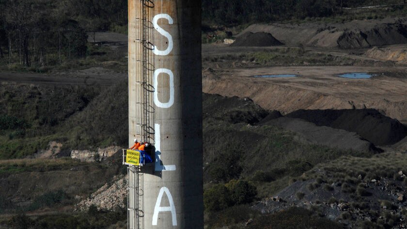 Protesters paint 'solar' on a smoke stack at Swanbank Power Station in July.