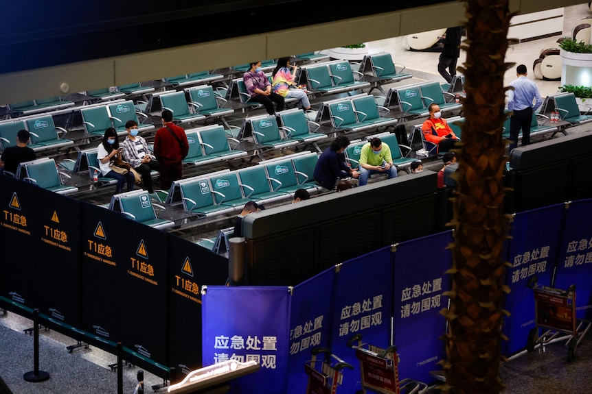 A handful of people wait in an airport lounge. 