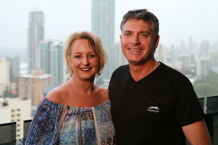 Michelle and Anthony Di Salvo stand on a high-rise balcony with the Gold Coast coastline in the background.