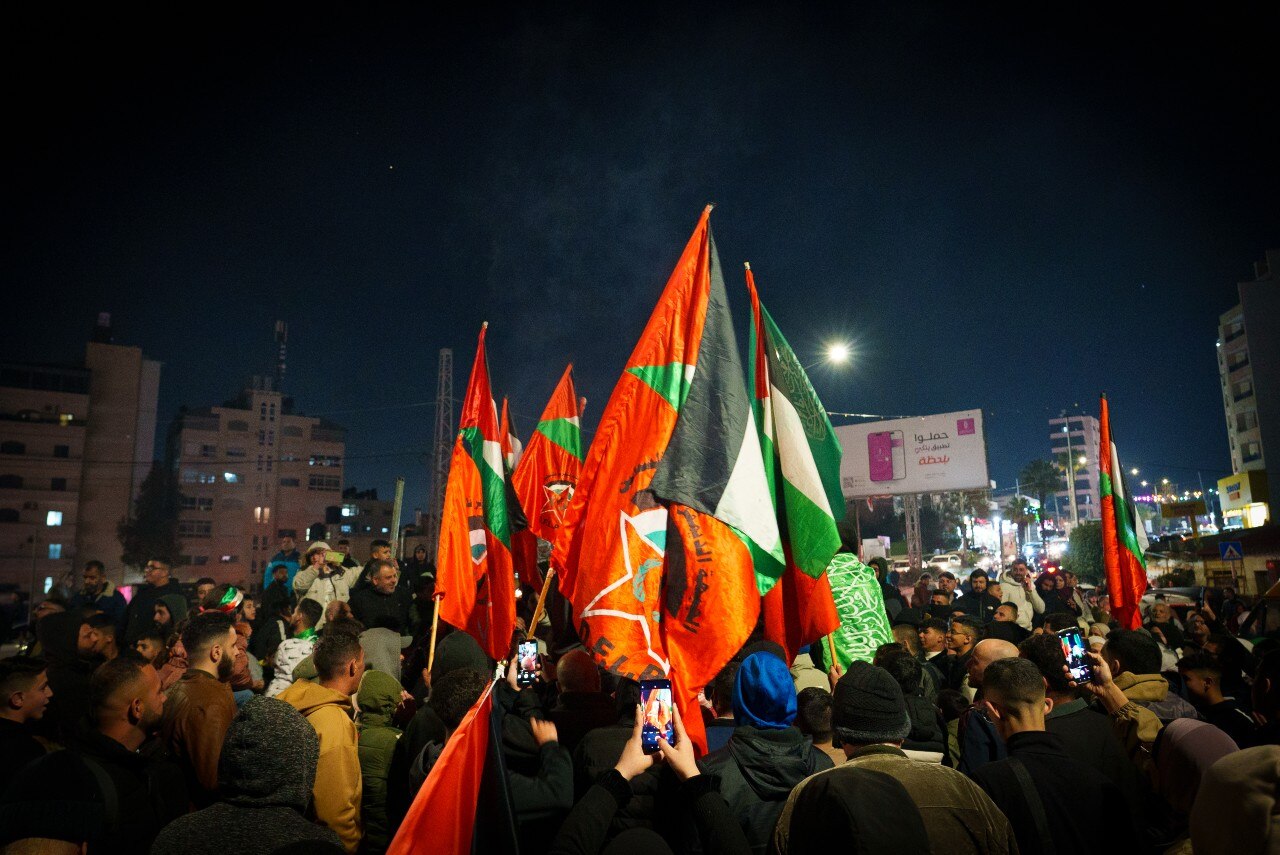 A large crowd including many people holding flags