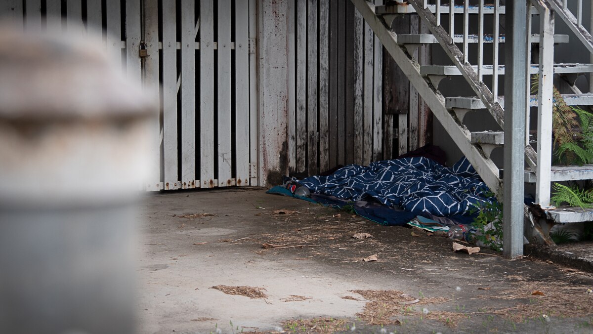 A blanket has been left beneath a wooden staircase of a Queenslander-style building