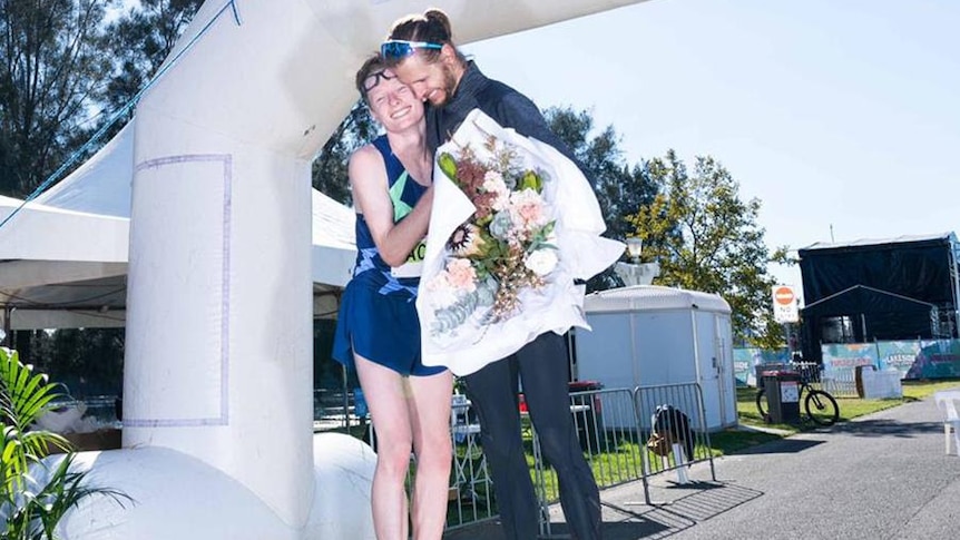 Two Australian athletes hug each other after breaking marathon world records.