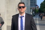 Matthew Paul Hockley, wearing sunglasses, walks in the street outside the District Court in Brisbane