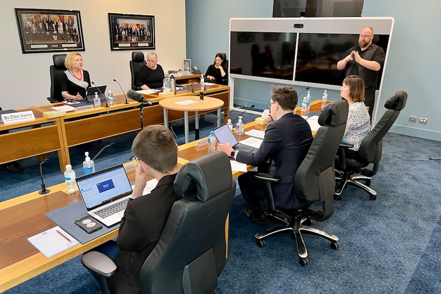 A group of people sit in a meeting room.