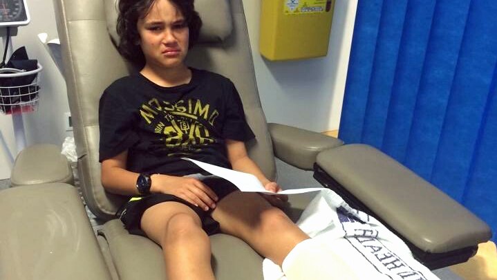 Romeo Paora looks sad wearing a leg cast in a hospital bed.
