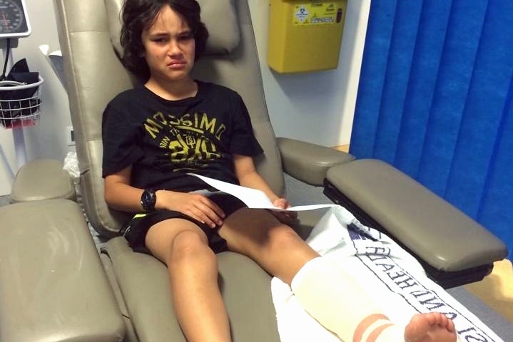 Romeo Paora looks sad wearing a leg cast in a hospital bed.