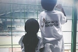 Two children looking at soccer field.