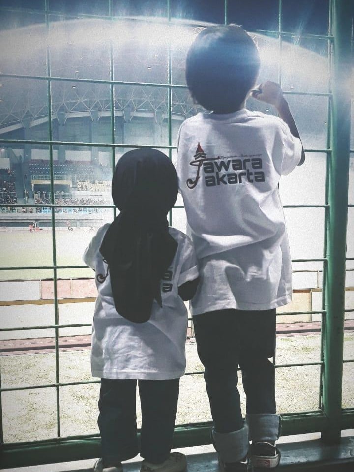 Dua anak melihat lapangan sepak bola.