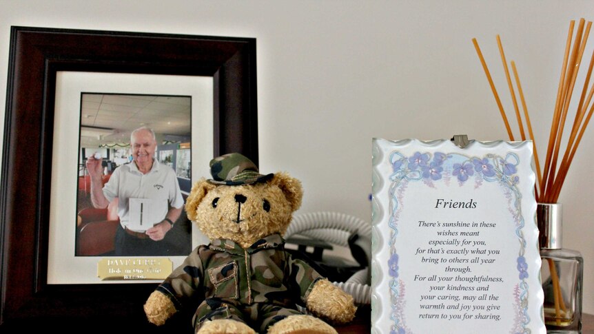Mantelpiece in David Curry's home, photograph of hole-in-one golf ball and army dressed teddy bear.