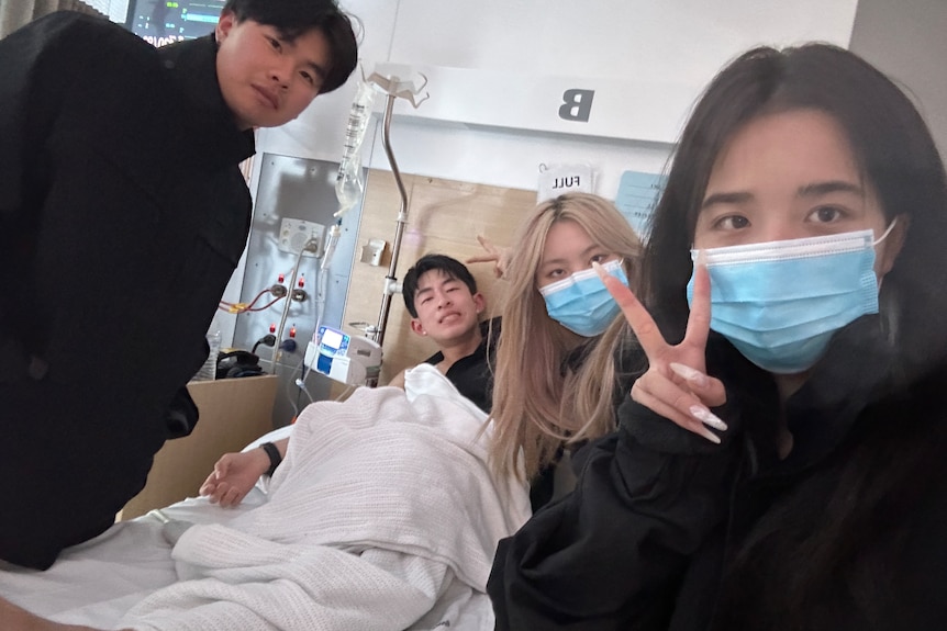 Four people in a hospital ward.