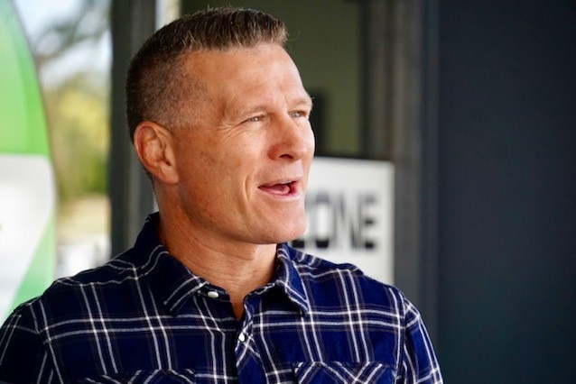 A mid shot of boxer Danny Green in a blue and white shirt talking outdoors.