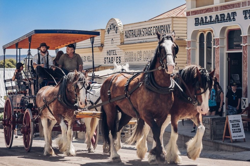 Before 1850s designed shop-fronts, horses pull a carriage in which a small group of people sit.